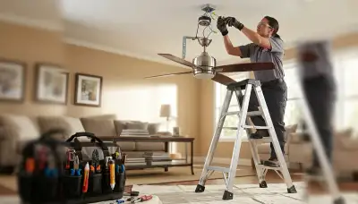 Electrician installing a ceiling fan in a Littleton, CO home