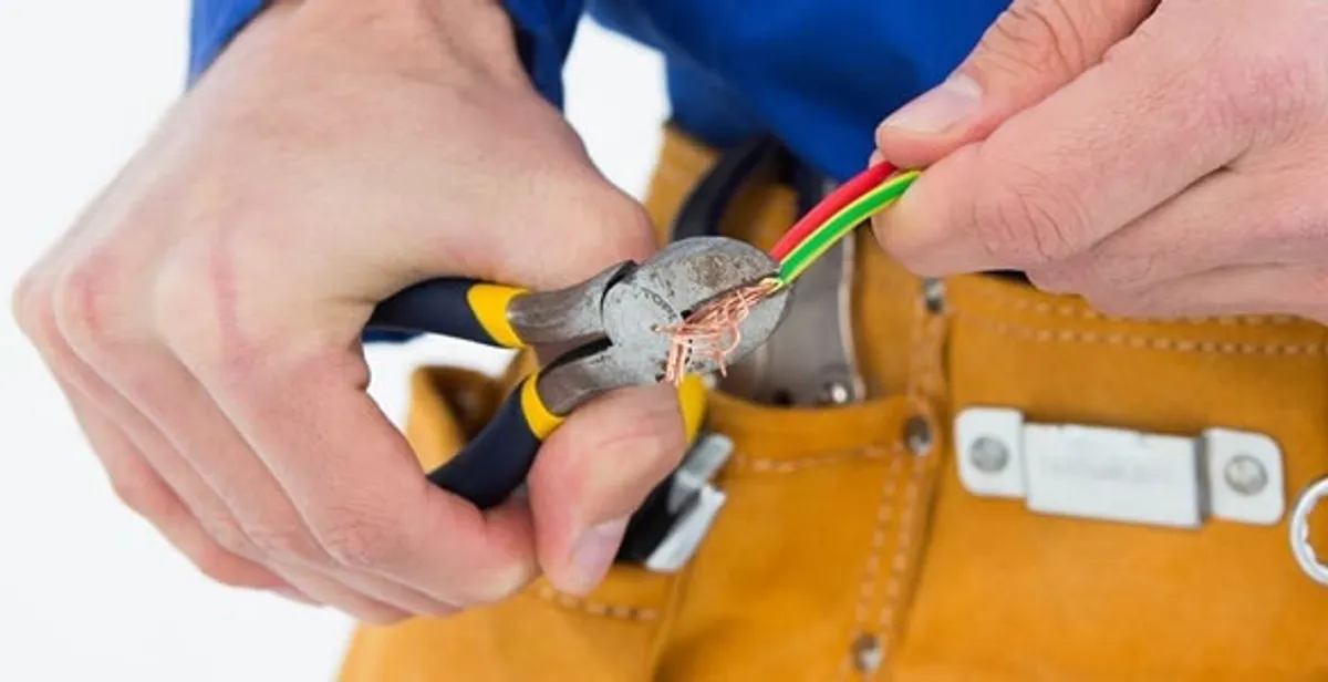 licensed electrician securing electrical wiring with professional tools during service work in Littleton, CO