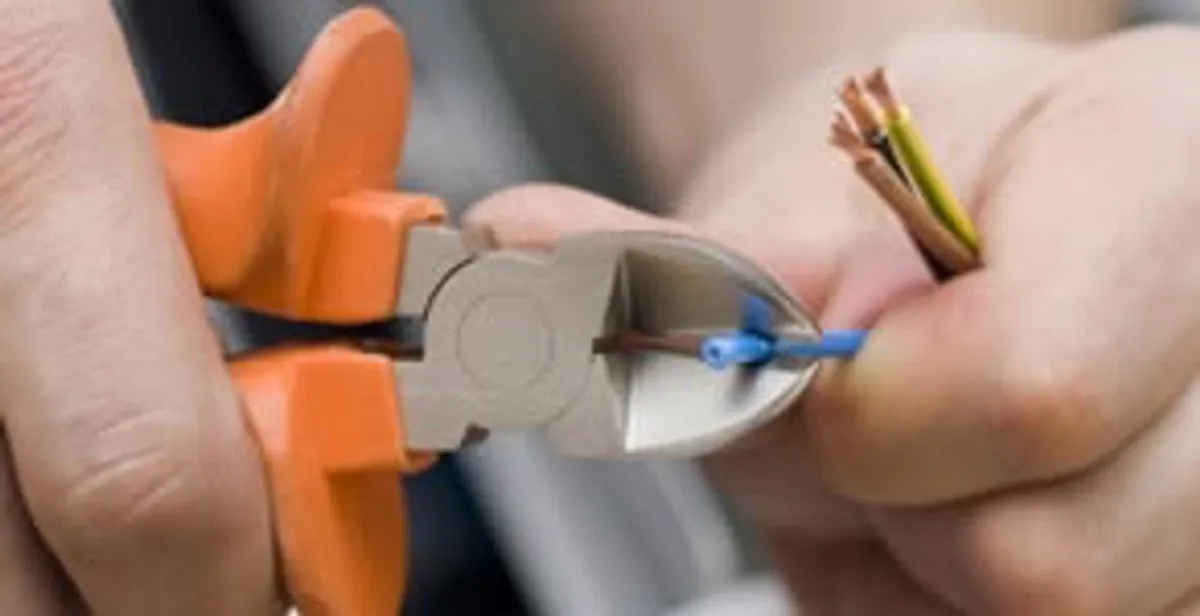 licensed electrician performing precise wire cutting and preparation during electrical service in Littleton, CO